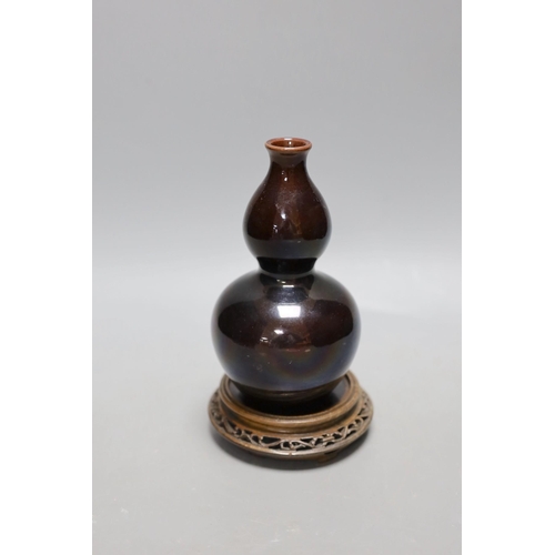 447 - A Chinese brown monochrome double gourd vase (on stand). 19cm tall