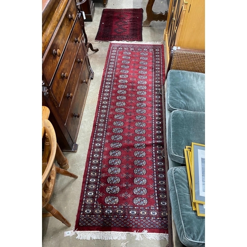 52 - A Bokhara red ground runner and an Afghan rug, larger 250cms x 80cms.