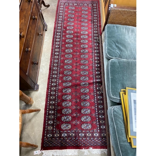 52 - A Bokhara red ground runner and an Afghan rug, larger 250cms x 80cms.