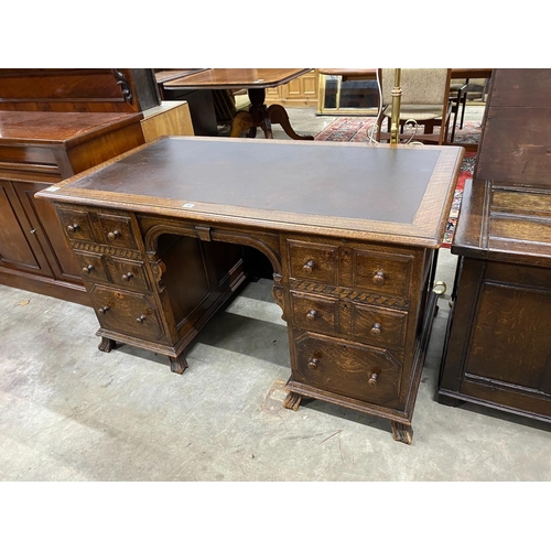 69 - An early 20th century oak kneehole desk, length 136cm, depth 75cm, height 75cm