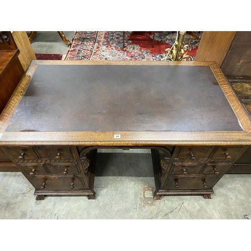 69 - An early 20th century oak kneehole desk, length 136cm, depth 75cm, height 75cm