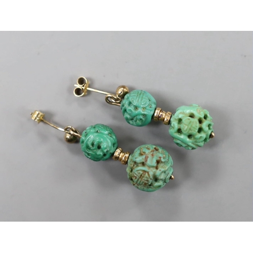 940 - A pair of Chinese yellow metal and two turquoise bead set earrings, both carved with Shou medallions... 