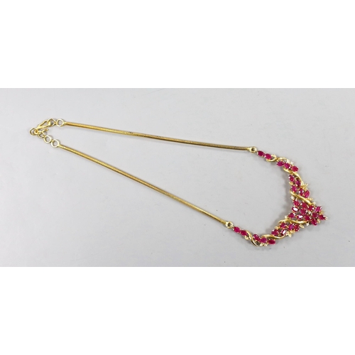 942 - A modern Thai yellow metal, oval cut ruby and diamond chip cluster set necklace, 40cm, gross 22.6 gr... 