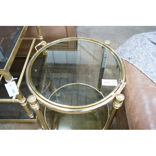 1035 - A circular smoked glass and brass tray top two tier occasional table, diameter 57cm, height 64cm... 