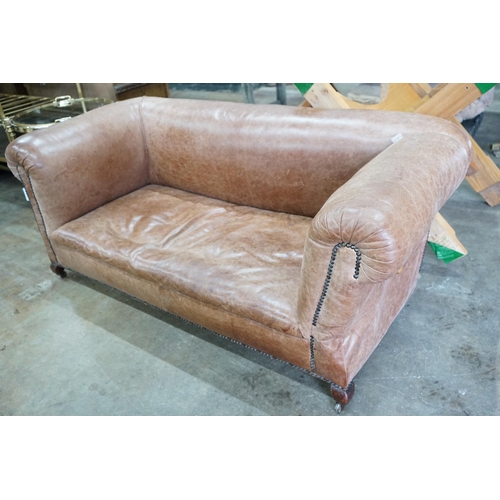 1036 - An early 20th century tan leather drop arm Chesterfield settee, width 160cms, depth 84cms, height 69... 