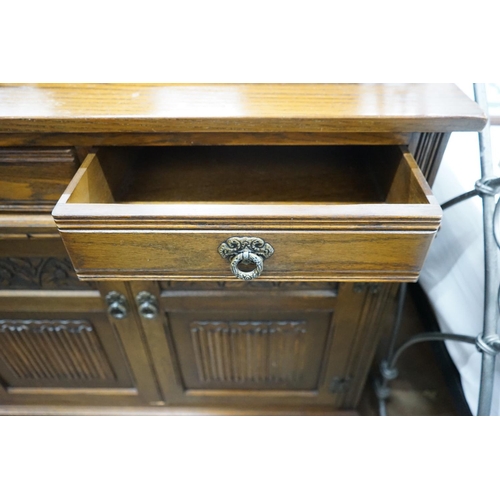 1039 - A reproduction 18th century style carved and linen fold moulded oak sideboard width 187cms, depth 44... 