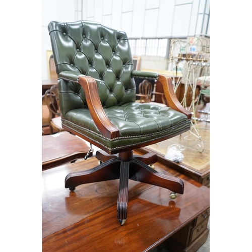 1048 - A reproduction mahogany and buttoned green leather swivel desk chair, width 56cm, depth 51cm, height... 