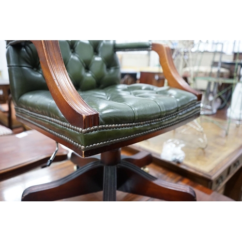 1048 - A reproduction mahogany and buttoned green leather swivel desk chair, width 56cm, depth 51cm, height... 