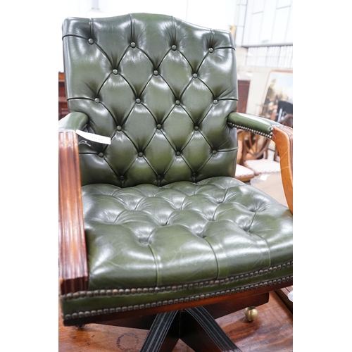 1048 - A reproduction mahogany and buttoned green leather swivel desk chair, width 56cm, depth 51cm, height... 