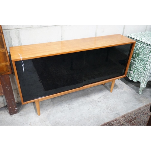 1054 - Robin Day for Hille, a teak and black glass sliding door side cabinet, width 137cms, depth 30cms hei... 