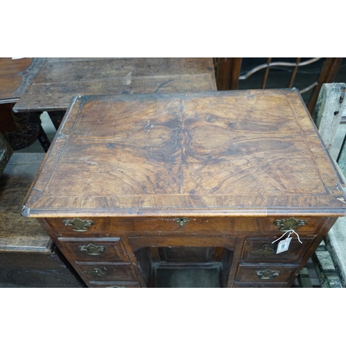 1071 - An 18th century feather banded walnut kneehole desk, width 81cms, depth 52cms, height 76cms.