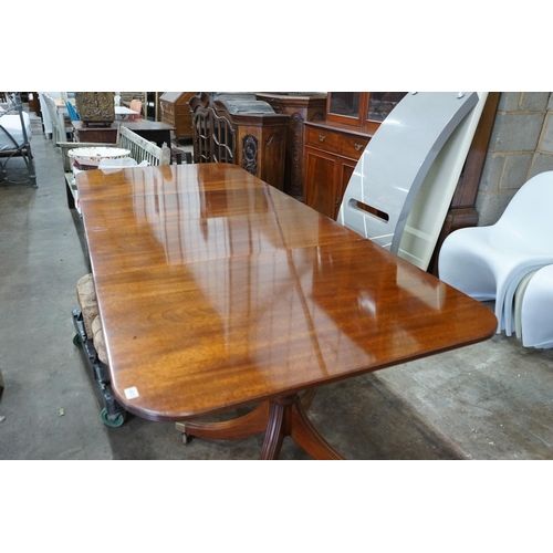 1073 - A reproduction Tillman style mahogany twin pillar extending dining table 246cms extended, two spare ... 