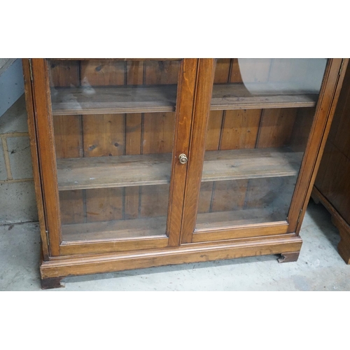 1081 - A Victorian style glazed walnut bookcase width 110cms, depth 26cms, height 136cms.