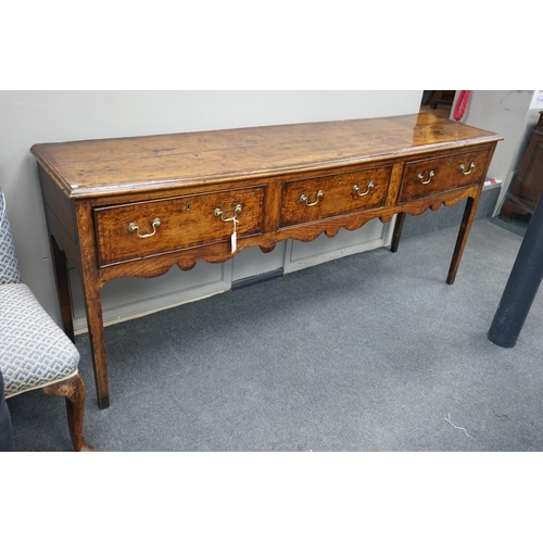 1163 - A George III provincial oak and mahogany banded low dresser with three drawers on square tapering le... 