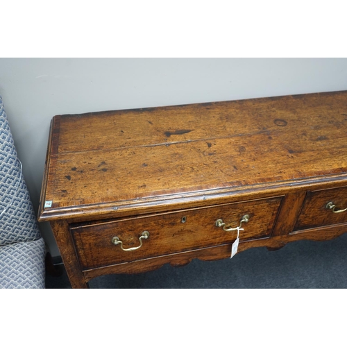 1163 - A George III provincial oak and mahogany banded low dresser with three drawers on square tapering le... 