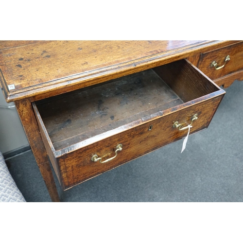 1163 - A George III provincial oak and mahogany banded low dresser with three drawers on square tapering le... 