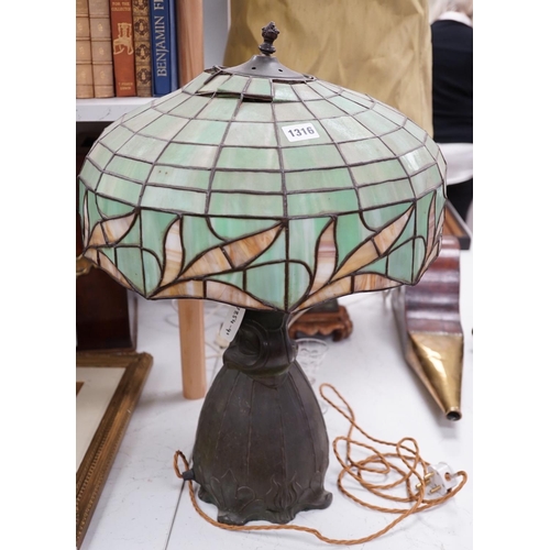 1316 - A spelter lamp with Tiffany style shade, 57cms high including shade