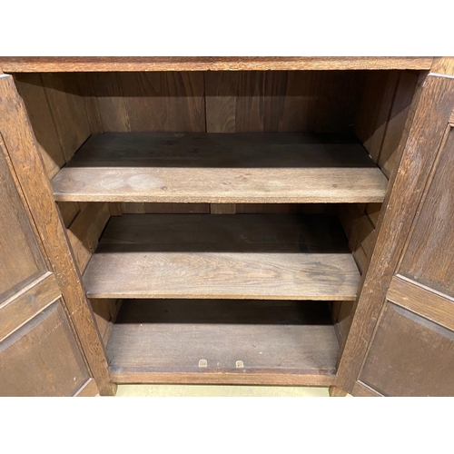 110 - A reproduction oak linenfold moulded two door side cabinet, width 91cm, depth 49cm, height 114cm... 