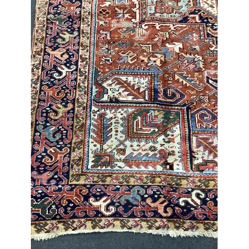 134 - An early 20th century Heriz red ground carpet, 336 x 250cm