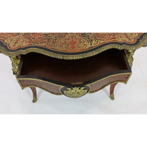 144 - A 19th century French red boulle bureau plat, of serpentine oval form with foliate scrolling inlaid ... 