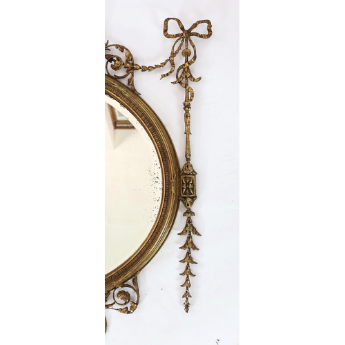 165 - A late Victorian Adam Revival oval wall mirror, with urn, foliate scroll, ribbon and harebell motifs... 