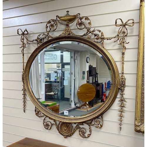 165 - A late Victorian Adam Revival oval wall mirror, with urn, foliate scroll, ribbon and harebell motifs... 