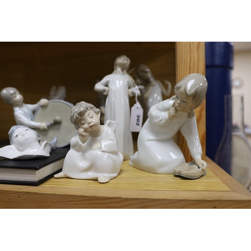 302 - A Lladro collection: seven figures, five further damaged figures and a Lladro reference book