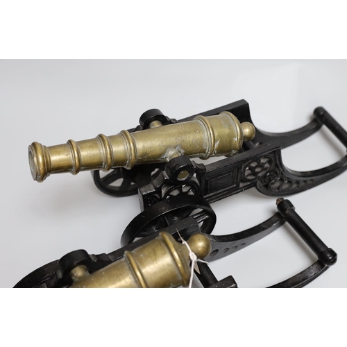 312 - A pair of cast iron and bronze model cannons and a cast iron dog nut cracker, cannons 42.5cm long... 