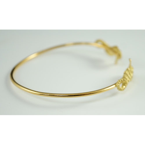 876 - A modern gold and diamond chip set open work bangle, each terminal modelled as a seahorse with diamo... 