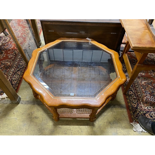 1019 - A modern octagonal brass mounted walnut glass top coffee table with caned undertier, diameter 100cm,... 