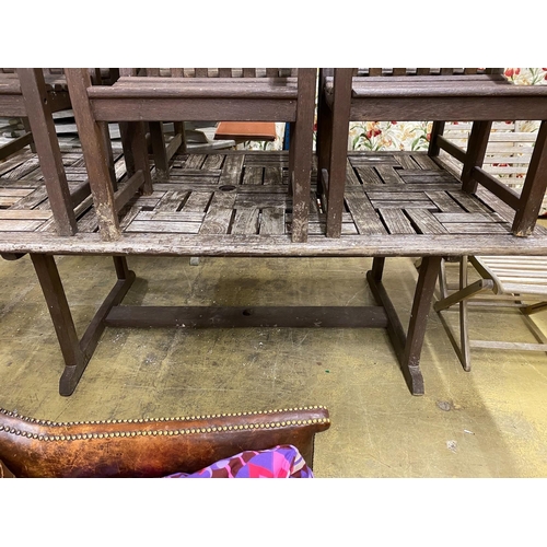 22 - A rectangular weathered teak garden table, length 212cm, width 110cm, height 74cm and six elbow chai... 