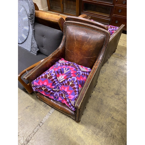 23 - A pair of early 20th century studded tan leather armchairs, width 66cm, depth 76cm, height 88cm... 