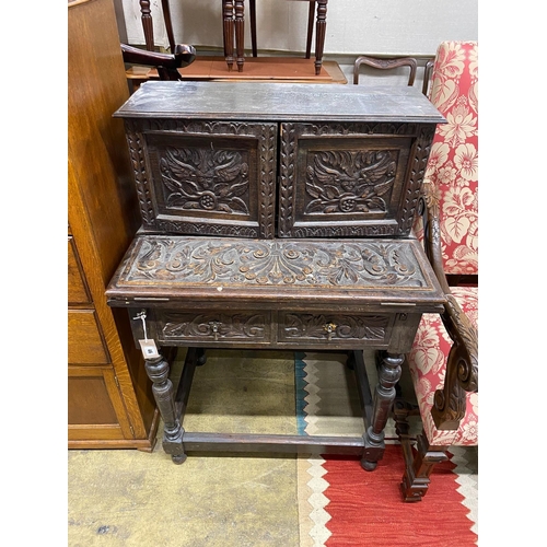 46 - A 1920's Jacobean Revival carved oak writing table, width 76cm, depth 50cm, height 109cm