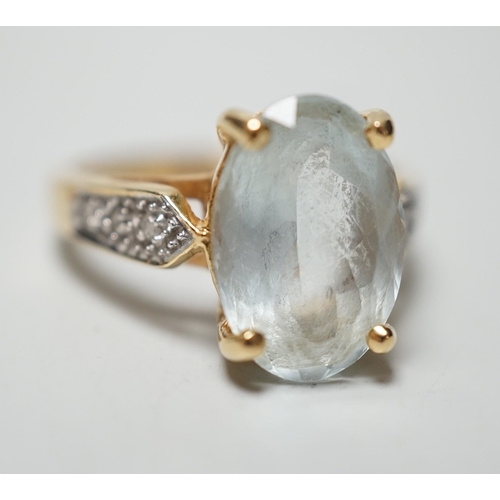 1946 - A modern 18ct gold and oval cut aquamarine set dress ring, with diamond chip set shoulders, size N, ... 