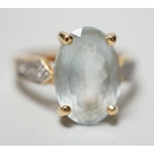 1946 - A modern 18ct gold and oval cut aquamarine set dress ring, with diamond chip set shoulders, size N, ... 