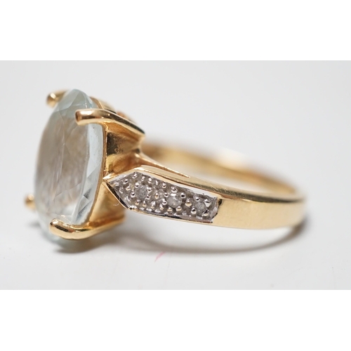 1946 - A modern 18ct gold and oval cut aquamarine set dress ring, with diamond chip set shoulders, size N, ... 