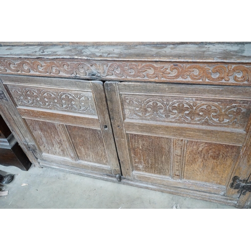 1011 - A 17th century carved oak court cupboard, dated 1685, width 170cm, depth 55cm, height 150cm