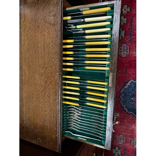 1043 - A part canteen of Walker & Hall silver plated Old English pattern cutlery, contained in an oak stand... 