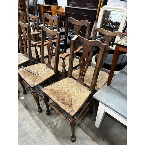 1053 - A set of ten George III style provincial oak rush seat dining chairs, two with arms.