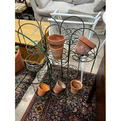 1060 - A wrought iron bicycle pot stand, height 98cm together with a pair of folding wirework pot stands... 