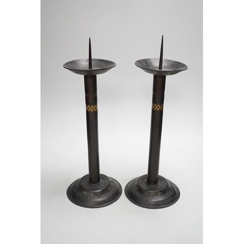 1294 - Attributed to Glasgow School of Art - a pair of Arts and Crafts pricket candlesticks. 40cm tall... 