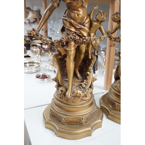 1340 - A pair of gilt spelter groups of a classical maiden and cherub, 61cm tall