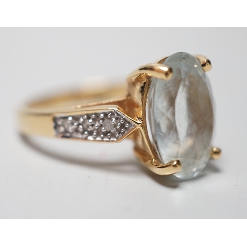 1946 - A modern 18ct gold and oval cut aquamarine set dress ring, with diamond chip set shoulders, size N, ... 