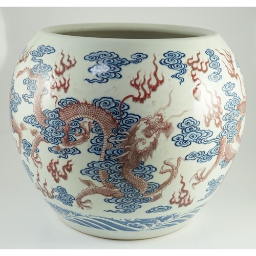 142 - A large Chinese underglaze blue and copper red 'dragon' scroll vessel, of globular form, painted in ... 