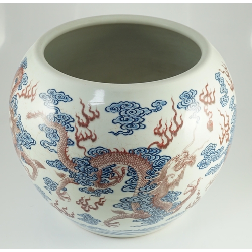 142 - A large Chinese underglaze blue and copper red 'dragon' scroll vessel, of globular form, painted in ... 