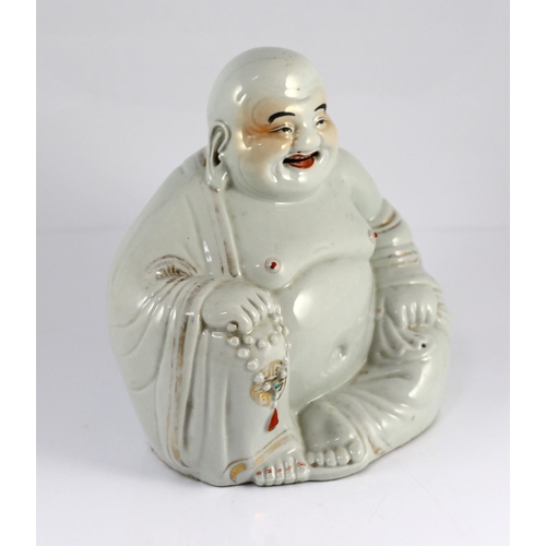 147 - A Chinese porcelain figure of Budai, Republic period, holding a rosary in his right hand, his robe i... 