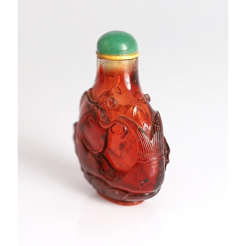 182 - A Chinese ruby red glass leaping carp snuff bottle, 1750-1850, each side carved in high relief wit... 