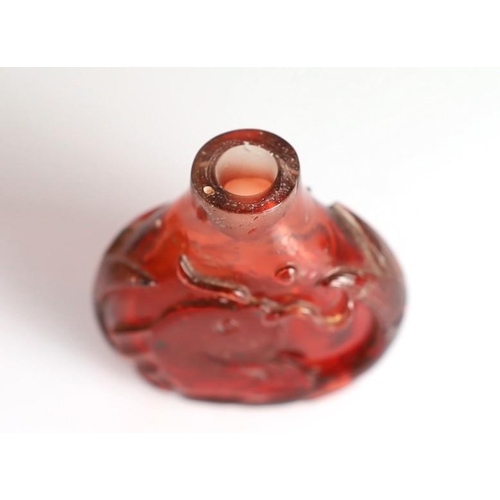 182 - A Chinese ruby red glass leaping carp snuff bottle, 1750-1850, each side carved in high relief wit... 