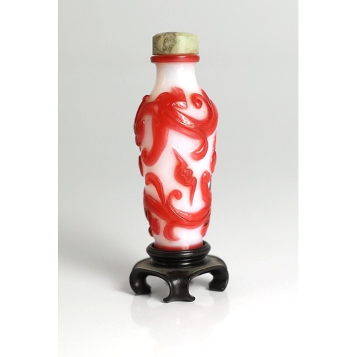 183 - A Chinese red overlay on white glass chilong snuff bottle, 1780-1850, carved in relief with two sc... 