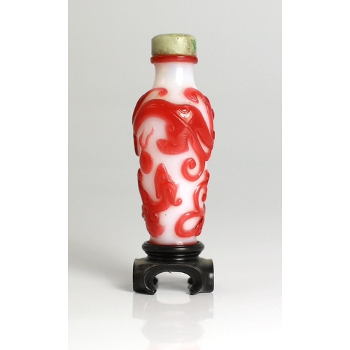 183 - A Chinese red overlay on white glass chilong snuff bottle, 1780-1850, carved in relief with two sc... 